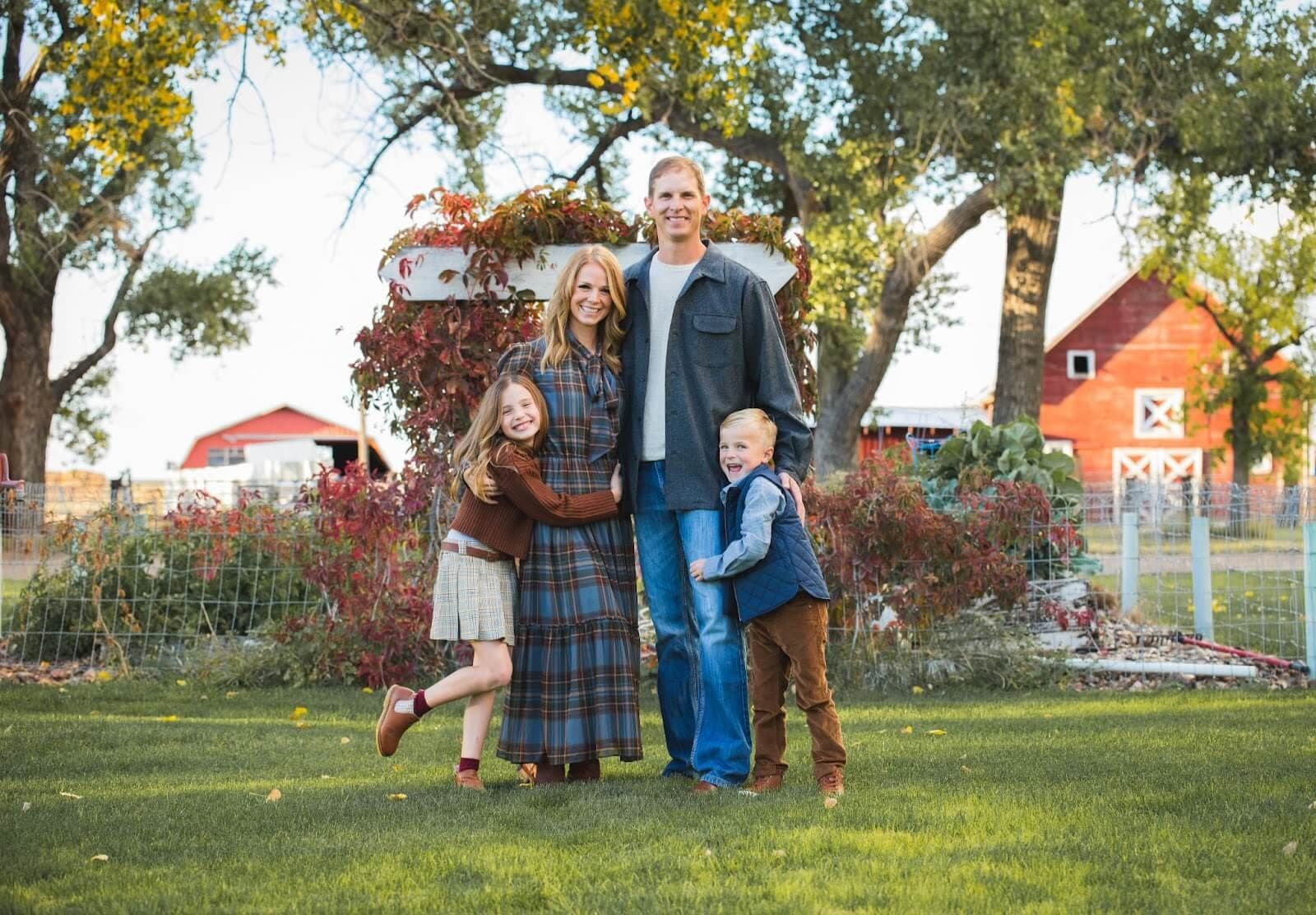 The Kilty family standing in front of the red barn at Bar X Ranch